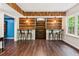 Stylish bar area with wood plank walls, a long countertop, pendant lights and hardwood floors, perfect for entertaining at 878 Treadstone Overlook, Suwanee, GA 30024