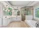 Bright bathroom features a corner shower, soaking tub, double vanity, and a stained glass window at 878 Treadstone Overlook, Suwanee, GA 30024