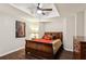 Bedroom featuring dark wood floors, tray ceiling with ceiling fan, and dark wood furniture at 878 Treadstone Overlook, Suwanee, GA 30024