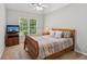 Cozy bedroom with wood frame bed, ceiling fan and neutral tones at 878 Treadstone Overlook, Suwanee, GA 30024