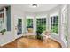 Cozy sunroom with multiple windows offering views of the surrounding trees and natural light at 878 Treadstone Overlook, Suwanee, GA 30024