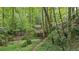 Secluded woodland area with mature trees and a wooden treehouse, providing a peaceful and natural escape at 878 Treadstone Overlook, Suwanee, GA 30024