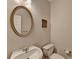 Half bathroom featuring a round mirror, white sink, and toilet at 2765 Turning Leaf Dr, Lawrenceville, GA 30044