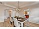 Elegant dining room with crown molding, chandelier, and seating for four at 2765 Turning Leaf Dr, Lawrenceville, GA 30044