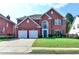 Charming brick two-story home with attached two car garage and well manicured lawn at 2765 Turning Leaf Dr, Lawrenceville, GA 30044