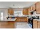 Well-equipped kitchen with wood cabinets, granite countertops, and a center island at 2765 Turning Leaf Dr, Lawrenceville, GA 30044