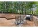 Inviting back deck with a dining table, BBQ grill, and a wooded view offering a relaxing outdoor space at 4816 Morning Chase Nw, Acworth, GA 30102