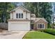 Charming home featuring a two-car garage, stone accents, and lush landscaping at 4816 Morning Chase Nw, Acworth, GA 30102