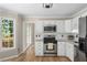 Charming kitchen featuring stainless steel appliances, white cabinets, and a window with a view of the outside at 4816 Morning Chase Nw, Acworth, GA 30102