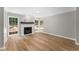 Bright living room featuring a fireplace, wood floors, and large windows overlooking the landscaped outdoors at 4816 Morning Chase Nw, Acworth, GA 30102