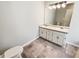 Bathroom with dual sinks, white cabinetry, a large mirror, and neutral tile floors at 1102 Ola Dale Ct, Mcdonough, GA 30252