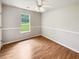 A bedroom with neutral walls, wood flooring, a ceiling fan, and a large window at 1102 Ola Dale Ct, Mcdonough, GA 30252