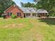 Inviting brick home featuring a well-manicured front yard and classic architectural details at 1102 Ola Dale Ct, Mcdonough, GA 30252