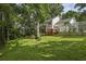 Spacious backyard with lush green grass, mature trees, and decks on the house at 1151 Roxboro Ne Cv, Atlanta, GA 30324