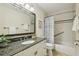 Well-lit bathroom featuring a granite countertop, framed mirror, and shower-tub combination at 1151 Roxboro Ne Cv, Atlanta, GA 30324