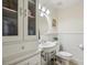 Charming half bathroom with beadboard paneling, vanity sink, storage cabinet and decorative details at 1151 Roxboro Ne Cv, Atlanta, GA 30324