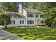 Charming two-story home with a lush green lawn, black shutters, and mature trees at 1151 Roxboro Ne Cv, Atlanta, GA 30324