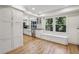 Bright kitchen features white cabinets, hardwood floors, stainless steel appliances, and large window with built-in seating at 1151 Roxboro Ne Cv, Atlanta, GA 30324