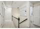 Upstairs hallway with carpet, white walls, black handrails, and doorways to bedrooms and bathrooms at 1151 Roxboro Ne Cv, Atlanta, GA 30324