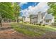 A large backyard with a pergola, mature trees, shrubs, and lawn at 1461 Radstone Dr, Lawrenceville, GA 30044