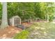 Private backyard with storage shed, mature trees, lawn, and a pergola sitting area at 1461 Radstone Dr, Lawrenceville, GA 30044