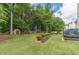 Fenced backyard features mature trees, green grass, storage building, pergola and hot tub at 1461 Radstone Dr, Lawrenceville, GA 30044