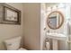 Elegant powder room featuring a pedestal sink, oval mirror, and decorative framed artwork at 1461 Radstone Dr, Lawrenceville, GA 30044