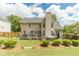 Back exterior featuring lush green lawn, hot tub, deck, and large trees at 1461 Radstone Dr, Lawrenceville, GA 30044