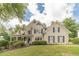 Charming two-story home with manicured lawn, mature trees, and classic architectural details at 1461 Radstone Dr, Lawrenceville, GA 30044