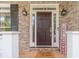Elegant entryway with a dark wood front door, sidelights, and a brick surround at 1461 Radstone Dr, Lawrenceville, GA 30044