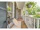 Inviting covered front porch with seating, brick flooring, and a decorative hanging plant at 1461 Radstone Dr, Lawrenceville, GA 30044