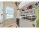 Well-lit laundry room with white washer and dryer, upper cabinets, and laundry-themed decor at 1461 Radstone Dr, Lawrenceville, GA 30044