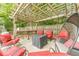 Covered patio with red chairs, a coffee table, and a hanging swing chair at 1461 Radstone Dr, Lawrenceville, GA 30044