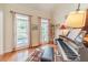Bright piano room featuring hardwood floors, a piano, and natural light through large windows at 1461 Radstone Dr, Lawrenceville, GA 30044