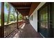 This back porch has stained wood floors and railings with a view of the backyard at 4214 Williamsburg Dr, College Park, GA 30337