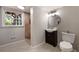 Bathroom with tiled shower, window view, and vanity with round mirror at 4214 Williamsburg Dr, College Park, GA 30337