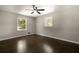 Bright bedroom with hardwood floors, two windows providing natural light, and a ceiling fan at 4214 Williamsburg Dr, College Park, GA 30337