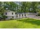 Charming two-story home with a well-manicured lawn, complemented by mature trees and a fresh, white facade at 4214 Williamsburg Dr, College Park, GA 30337