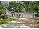 Exterior view of a beautifully renovated home showcasing its brick accents, wide driveway, and attached garage at 4214 Williamsburg Dr, College Park, GA 30337