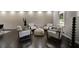A well-lit living room featuring four chairs surrounding a plush ottoman and dark, polished hardwood floors at 4214 Williamsburg Dr, College Park, GA 30337