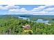 Breathtaking aerial view of a luxury home surrounded by lush green trees and the serene waters of Lake Keowee at 52 Waterside Se Dr, Cartersville, GA 30121