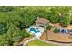 Aerial view of the property, featuring the stone-clad home, large pool, a driveway with parking, and dense surrounding trees at 52 Waterside Se Dr, Cartersville, GA 30121