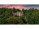 Multi-story home with multiple decks nestled among lush green trees, offering privacy and scenic views at sunset at 52 Waterside Se Dr, Cartersville, GA 30121