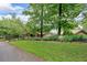 Charming home featuring a neatly manicured lawn, mature trees, and beautifully landscaped garden beds at 52 Waterside Se Dr, Cartersville, GA 30121