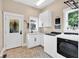Bright laundry room with modern appliances, white cabinets, and patterned tile flooring at 52 Waterside Se Dr, Cartersville, GA 30121