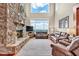 Living room features hardwood floors, a stone fireplace, neutral paint, and a wall of windows with a view of the mountains at 52 Waterside Se Dr, Cartersville, GA 30121