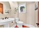 Charming powder room features a pedestal sink, round mirror, and a window with natural light at 52 Waterside Se Dr, Cartersville, GA 30121
