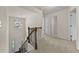 Upstairs hallway features neutral carpet, white trim, a view of the stairwell and entryway, and multiple doors at 6468 Panasa Ct, Tucker, GA 30084