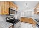 Well-lit kitchen with granite counters, wood cabinets, stainless steel appliances and ceramic tile flooring at 106 Brighton Pt, Sandy Springs, GA 30328