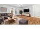 Bright living room features wood flooring, a large sectional, and natural light from the french doors at 106 Brighton Pt, Sandy Springs, GA 30328
